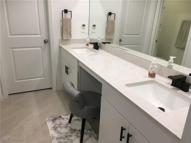 full bathroom with double vanity, a sink, and tile patterned floors