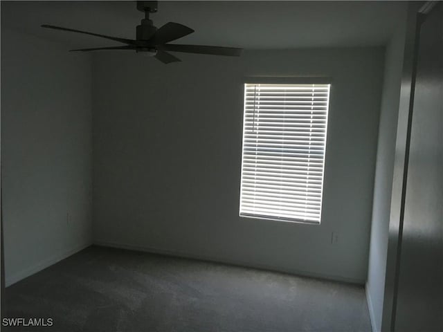 empty room with ceiling fan, carpet floors, and baseboards