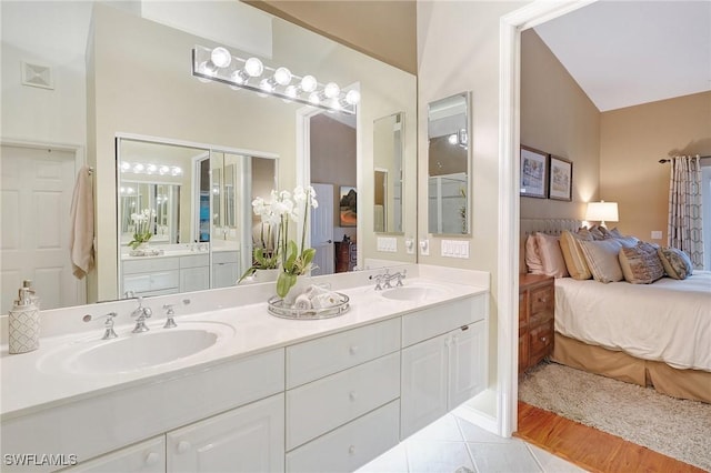 bathroom with vanity, tile patterned flooring, and vaulted ceiling