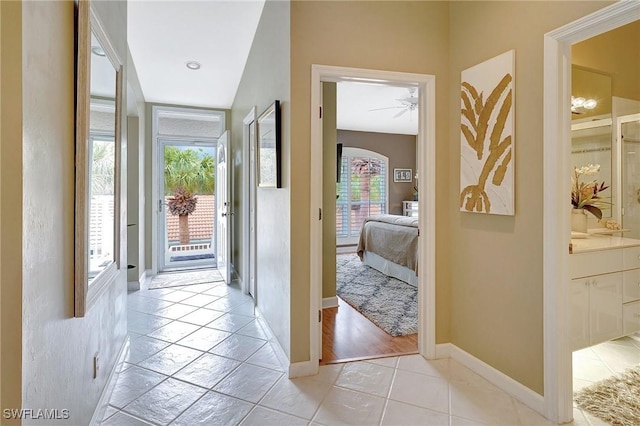 hallway with lofted ceiling and light tile patterned flooring