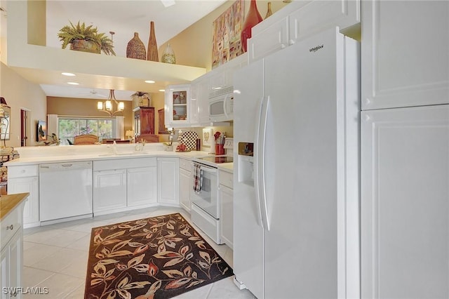 kitchen with light tile patterned floors, white appliances, and white cabinets