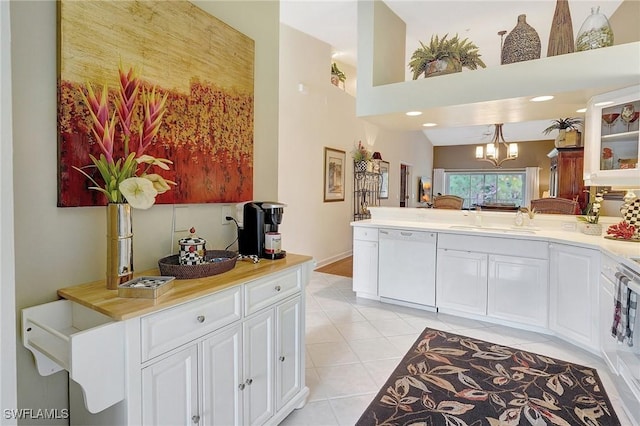 kitchen with pendant lighting, sink, white cabinetry, and dishwasher