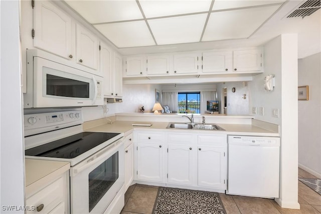 kitchen featuring white cabinetry, sink, white appliances, and light tile patterned floors