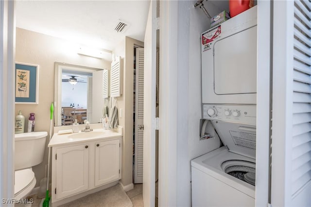 laundry room with stacked washer / drying machine, sink, and ceiling fan