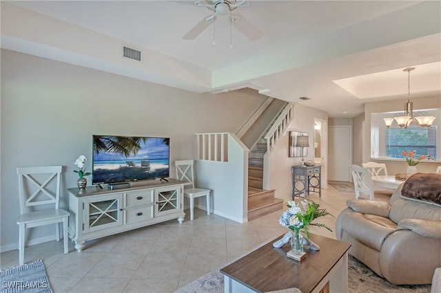 tiled living room with ceiling fan with notable chandelier