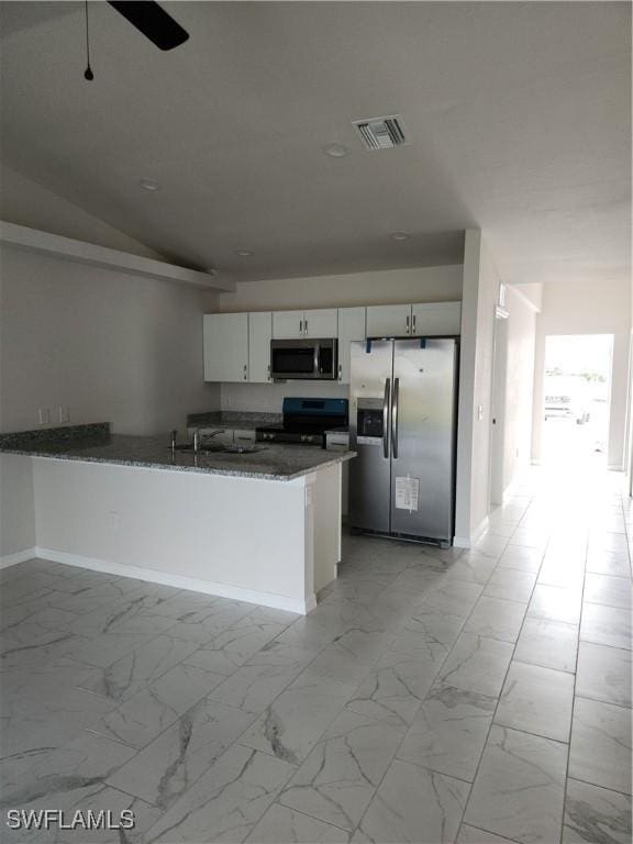 kitchen featuring dark stone counters, white cabinets, ceiling fan, kitchen peninsula, and stainless steel appliances