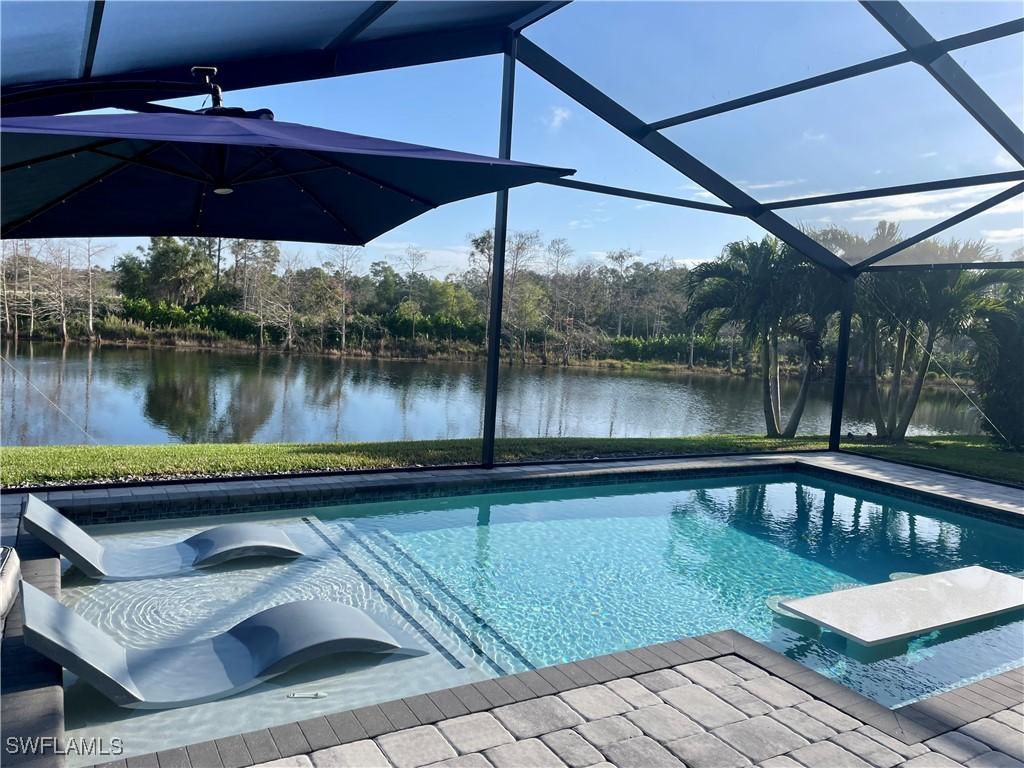 view of pool with glass enclosure and a water view