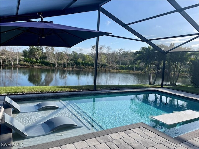 view of pool with glass enclosure and a water view