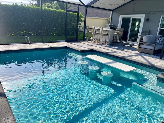 view of swimming pool featuring exterior bar, a lanai, and a patio area