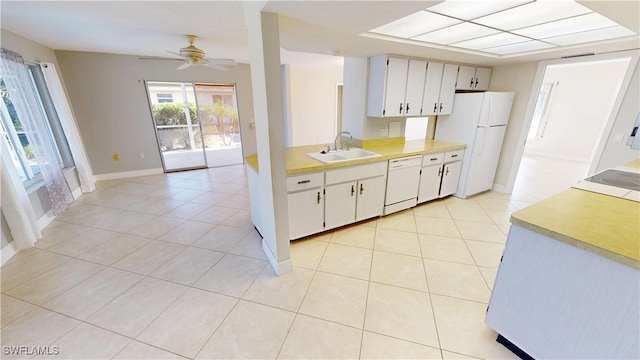 kitchen featuring white cabinetry, sink, light tile patterned flooring, and white appliances