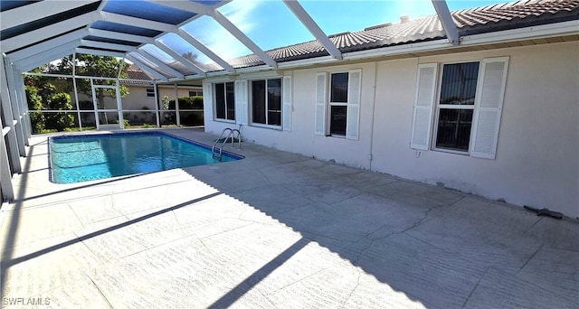 view of swimming pool with a patio area and a lanai