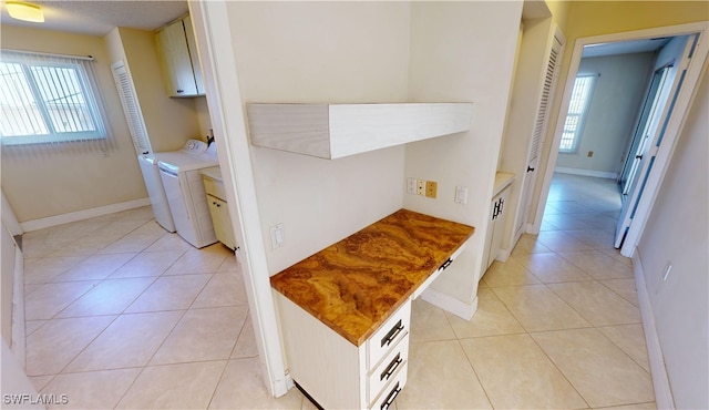 hall featuring light tile patterned floors, washing machine and dryer, and a wealth of natural light