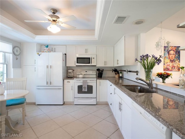 kitchen featuring a raised ceiling, white appliances, white cabinetry, and sink