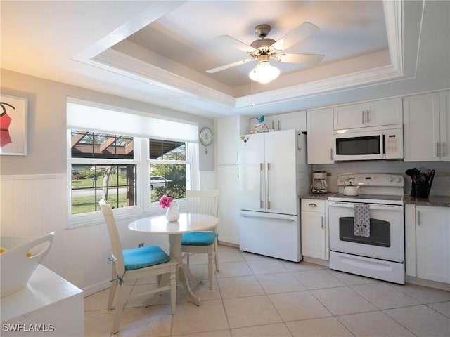 kitchen with white cabinetry, white appliances, and a tray ceiling