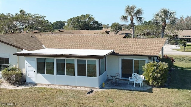 rear view of property featuring a lawn and a patio