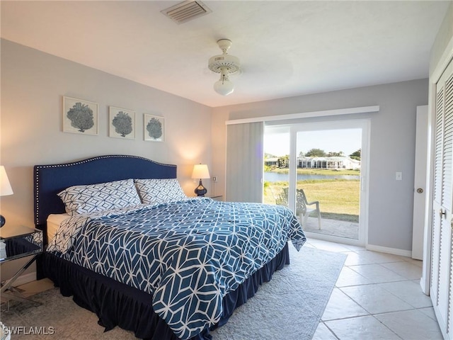 tiled bedroom featuring access to exterior, a water view, a closet, and ceiling fan