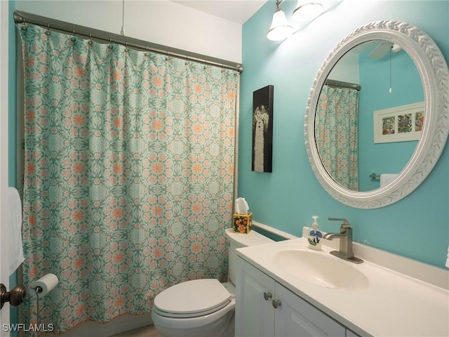 bathroom featuring vanity, a shower with shower curtain, and toilet