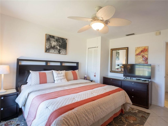 tiled bedroom featuring ceiling fan and a closet