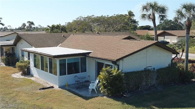 back of house with a patio area, a sunroom, and a yard