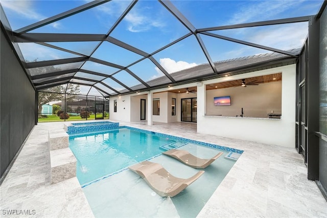 view of pool featuring a patio, glass enclosure, and ceiling fan