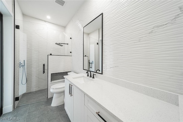 bathroom featuring vanity, toilet, and a shower with door