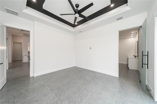 unfurnished room featuring a tray ceiling and ceiling fan