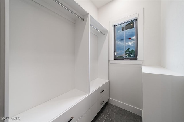 spacious closet featuring dark tile patterned flooring