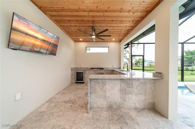 interior space with ceiling fan, sink, beverage cooler, wooden ceiling, and light stone counters