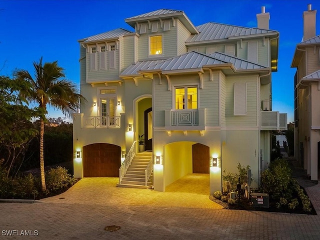 5801 Cape Hickory Ct, Bonita Springs, FL 34134 - view of front of home with a standing seam roof, a balcony, metal roof, a garage, and decorative driveway