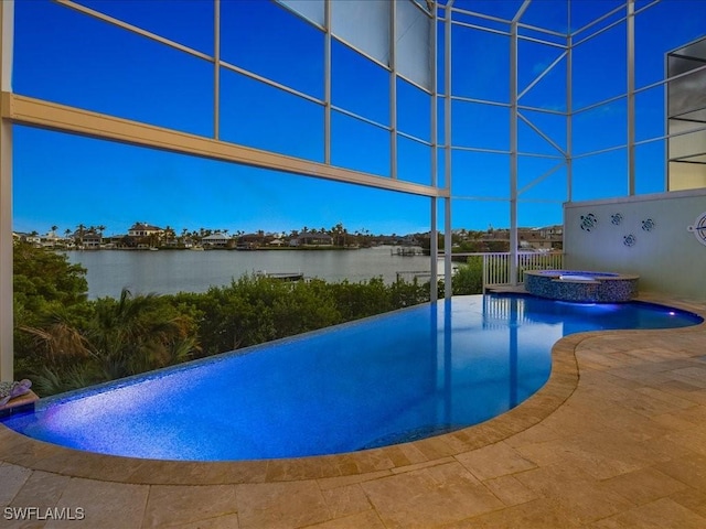 view of pool featuring an in ground hot tub, a water view, and a patio