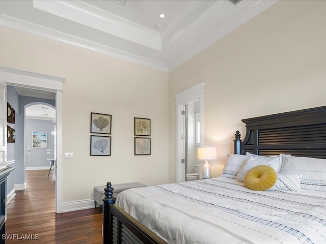 bedroom with crown molding, dark hardwood / wood-style flooring, and a tray ceiling