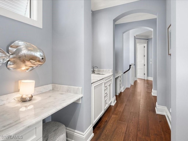 corridor with dark hardwood / wood-style flooring and sink