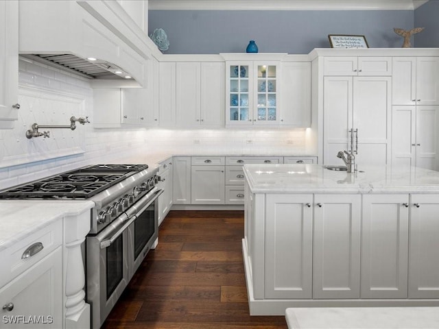 kitchen featuring dark wood-type flooring, double oven range, light stone counters, custom range hood, and white cabinets