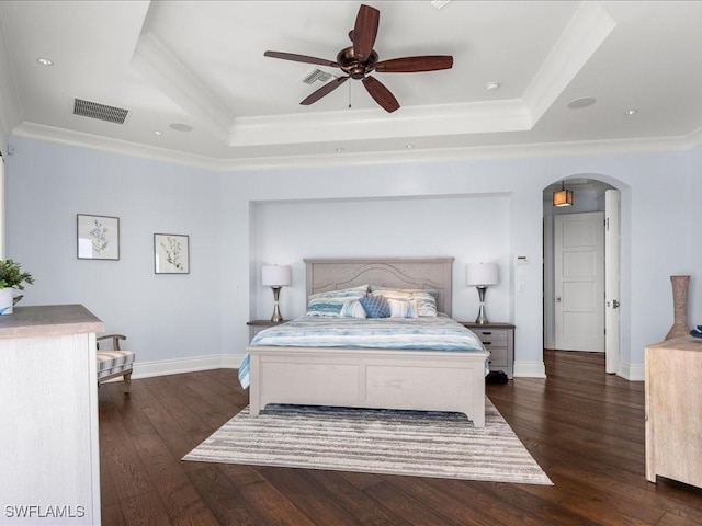 bedroom featuring a raised ceiling, crown molding, and dark hardwood / wood-style flooring