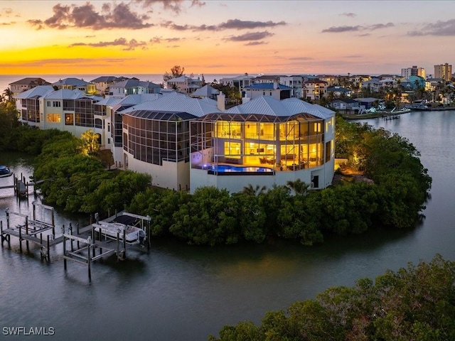 5801 Cape Hickory Ct, Bonita Springs, FL 34134 - back of property at dusk featuring boat lift and a water view