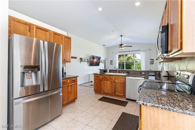 kitchen with kitchen peninsula, ceiling fan, stainless steel appliances, lofted ceiling, and sink