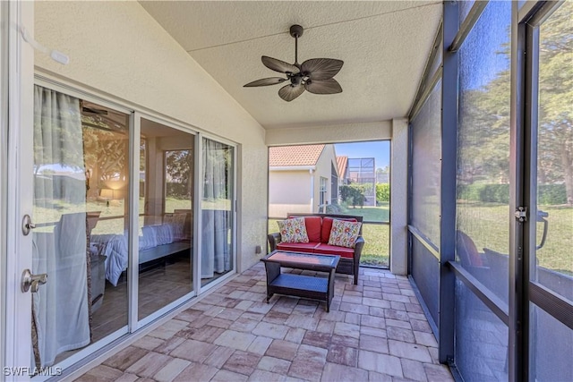 sunroom featuring lofted ceiling and ceiling fan