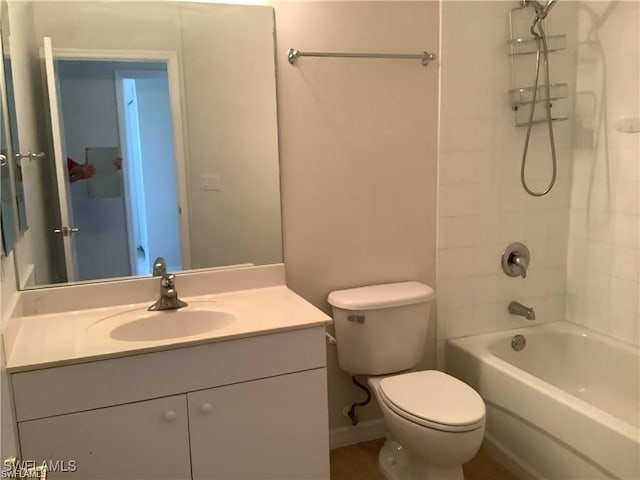 full bathroom featuring vanity, tiled shower / bath combo, and toilet