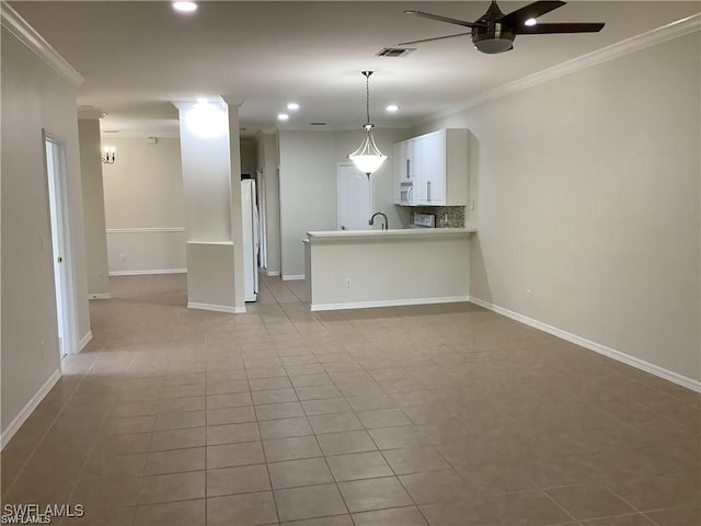 unfurnished living room with ceiling fan, sink, light tile patterned floors, and ornamental molding