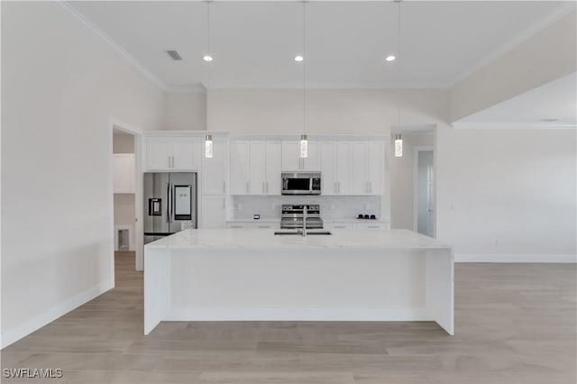 kitchen with a spacious island, white cabinetry, pendant lighting, and stainless steel appliances