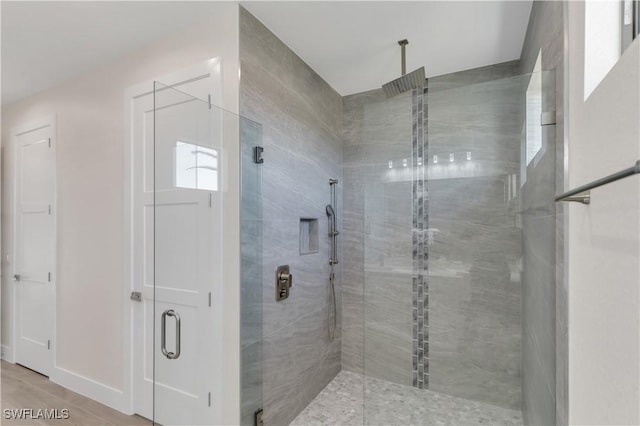 bathroom featuring hardwood / wood-style flooring and a shower with door