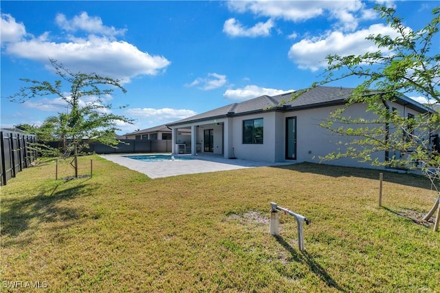 back of property with a patio and a lawn