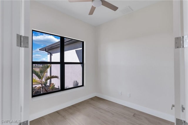 spare room featuring a wealth of natural light, ceiling fan, and light wood-type flooring