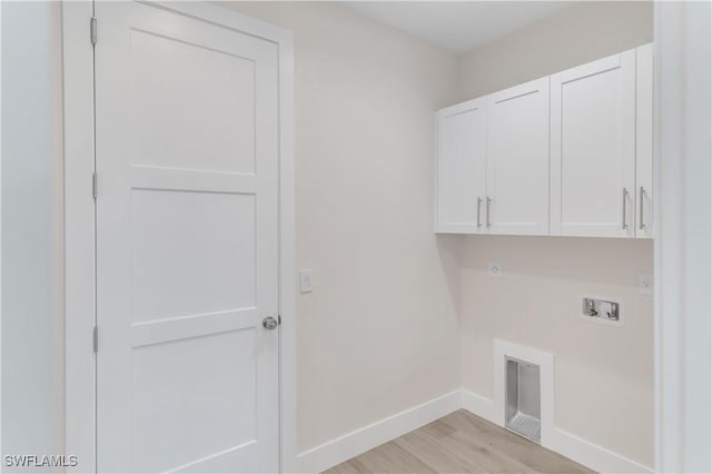 laundry area with cabinets, hookup for a washing machine, light hardwood / wood-style flooring, and electric dryer hookup