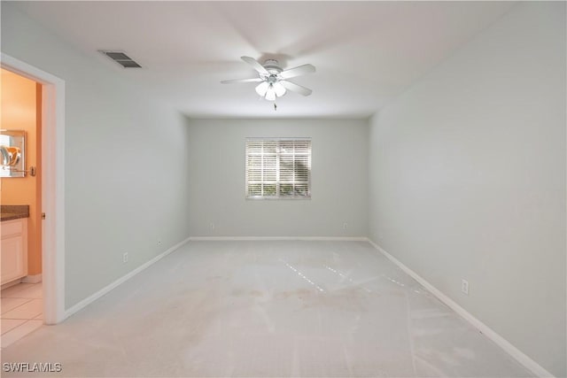 spare room with ceiling fan and light colored carpet