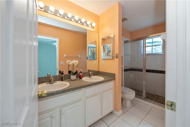 bathroom featuring vanity, an enclosed shower, tile patterned flooring, and toilet