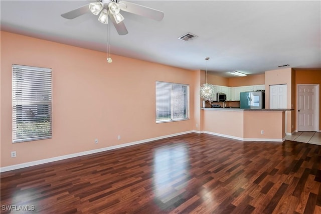 unfurnished living room featuring ceiling fan and dark hardwood / wood-style flooring