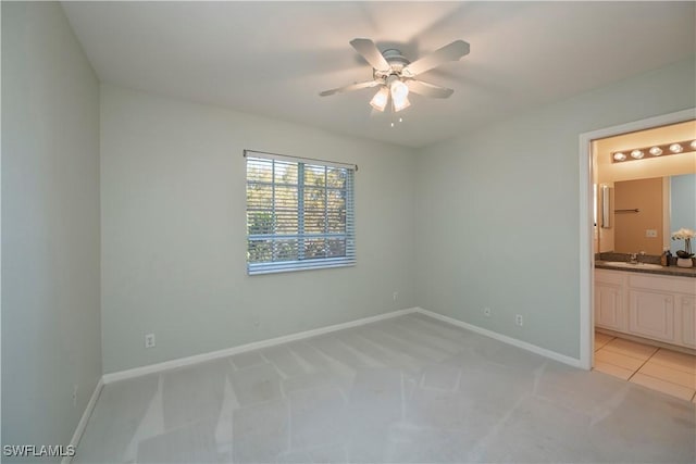 carpeted spare room featuring sink and ceiling fan