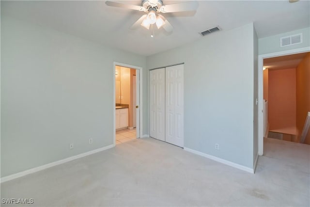 unfurnished bedroom with ceiling fan, ensuite bathroom, a closet, and light carpet