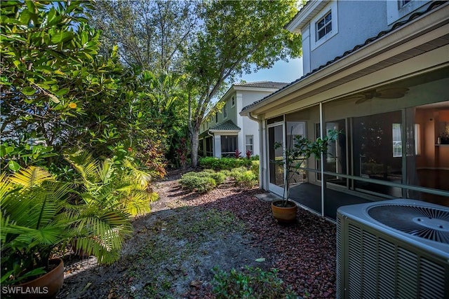 view of yard featuring central air condition unit and a sunroom